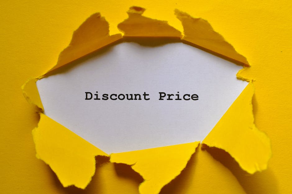 A close-up image showing a piece of torn, bright yellow paper with jagged edges, revealing a white inner layer with the phrase 'Discount Price' printed in black serif font. The torn paper appears to be layered, with the yellow outer layer curling slightly away from the white inner sheet. The background is a plain, solid yellow surface that matches the outer torn layer, creating a cohesive, visually striking contrast with the white paper. The torn edges are irregular and crinkled, suggesting a deliberate or accidental tear, and provide a textured look. The focus is sharply on the paper, with soft shadows cast around the torn edges, emphasizing depth. This visual can relate to cost-saving themes often associated with discounted or alternative waste management solutions, subtly connecting to the notion of private or independent waste removal services, such as those offered by Waste Clearance Finchley for rubbish disposal in the Finchley area.